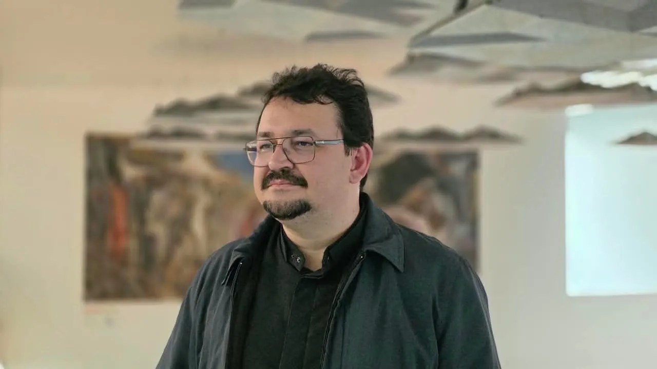 Padre Jocleilson eleva a hóstia durante a missa, diante do mural do presbitério